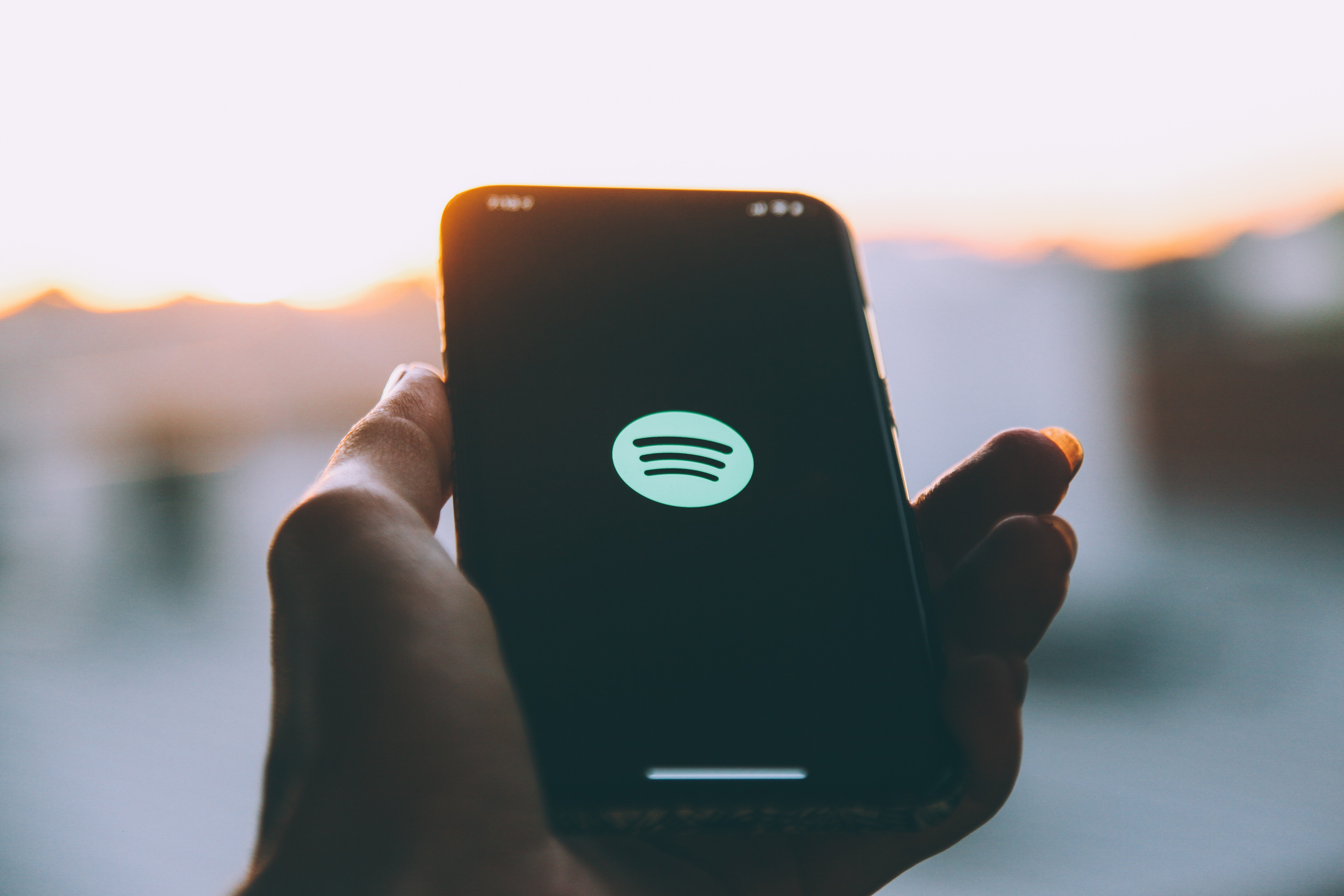 hand-holding-phone-displaying-music-service-logo-2026-03-17-04-00-32-utc