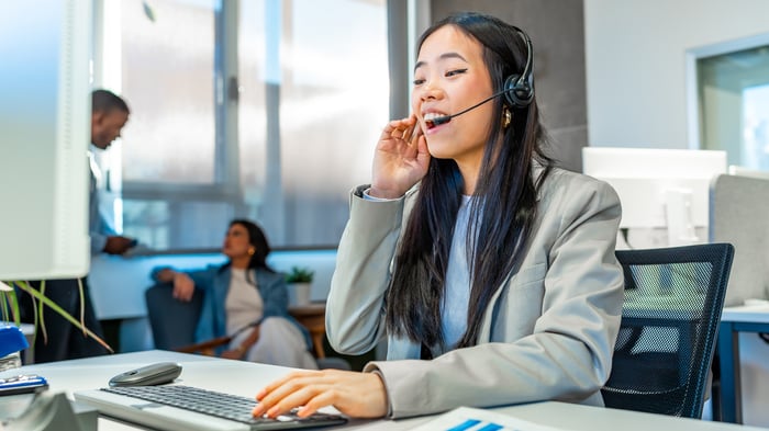 Asian businesswoman working with headset in coworking office
