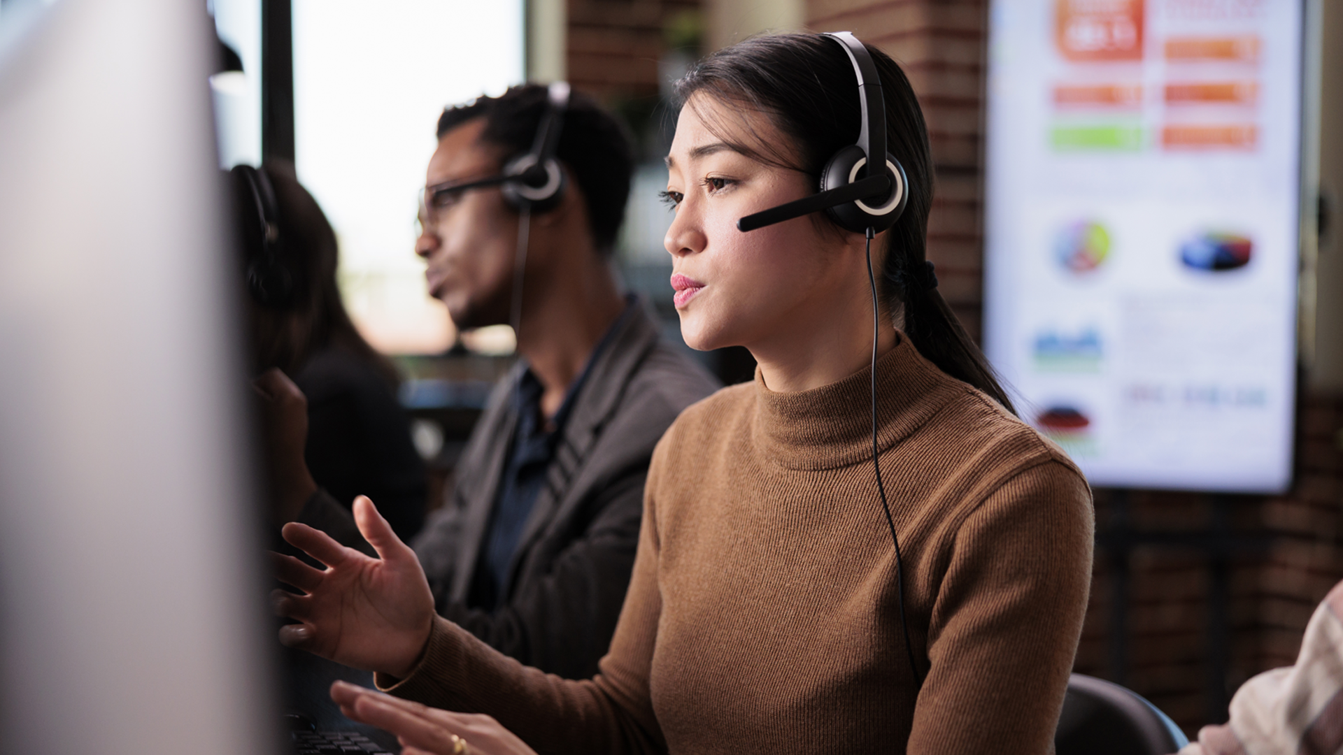 Asian female receptionist working at customer service helpdesk