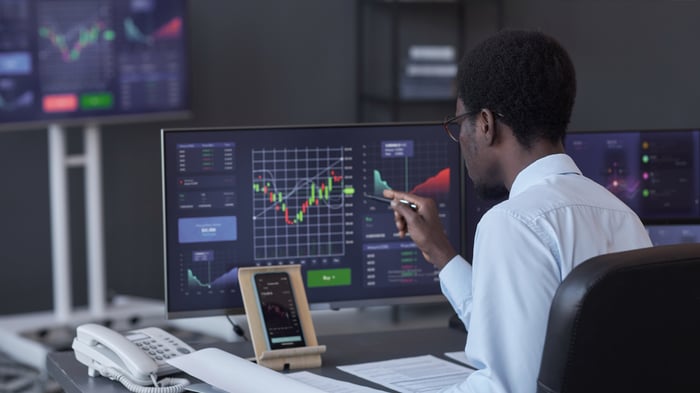 Broker analyzing stock market in office By seventyfourimages_L0