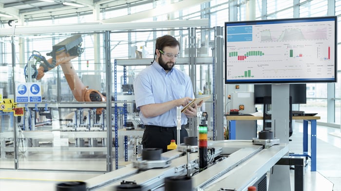 Engineer testing a robotic production simulator in robotics research facility