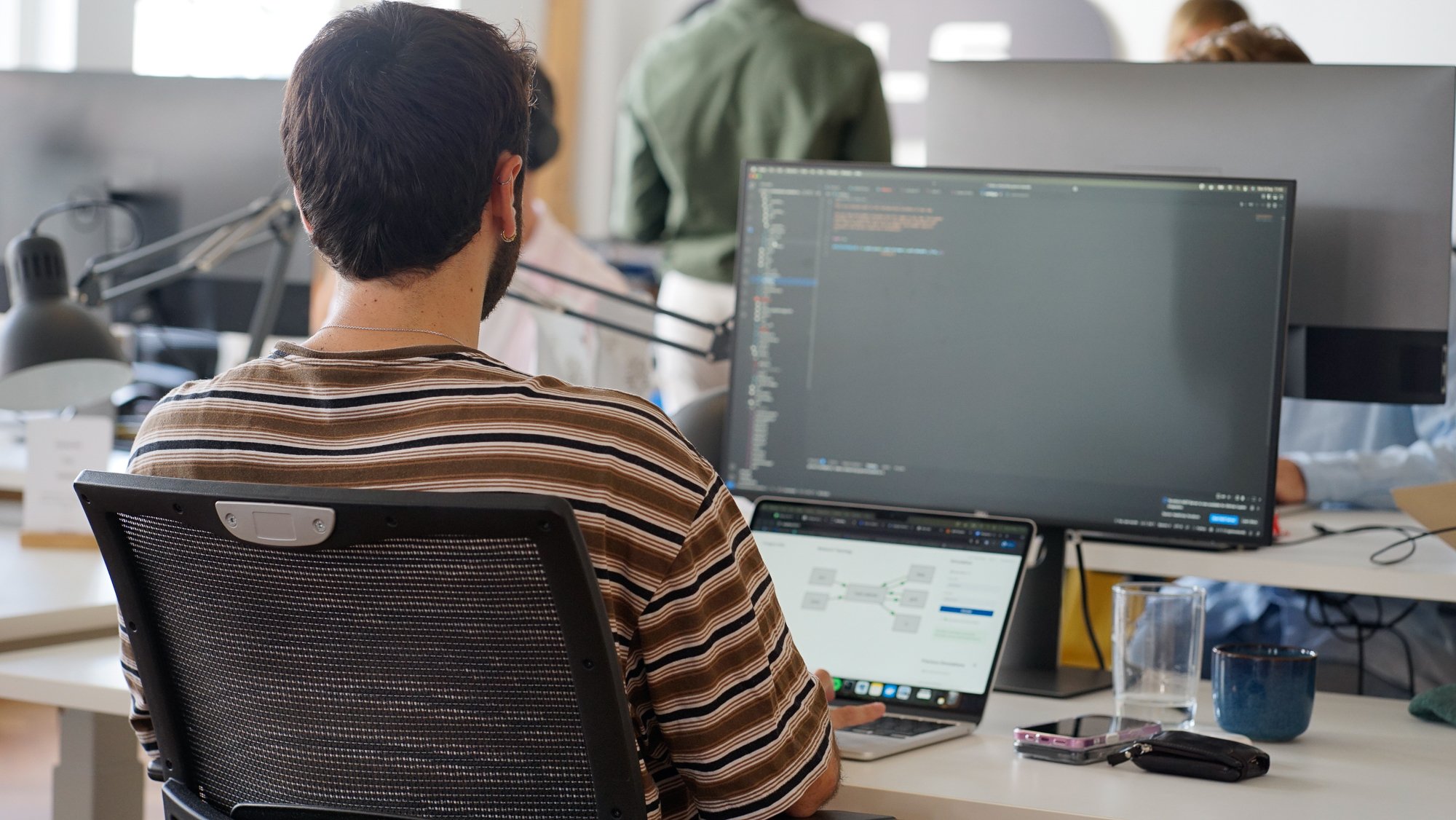 Man behind a screen typing code