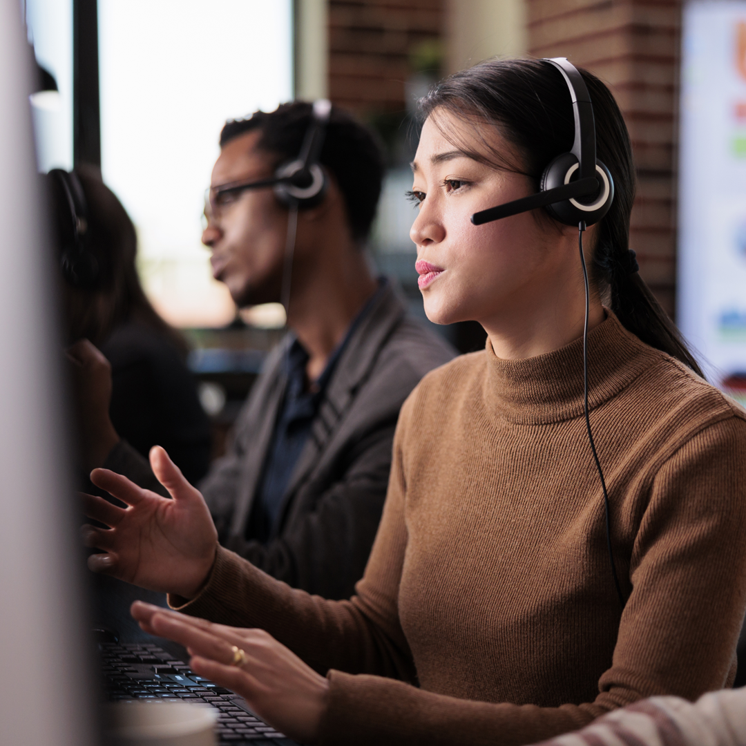 Asian female receptionist working at customer service helpdesk