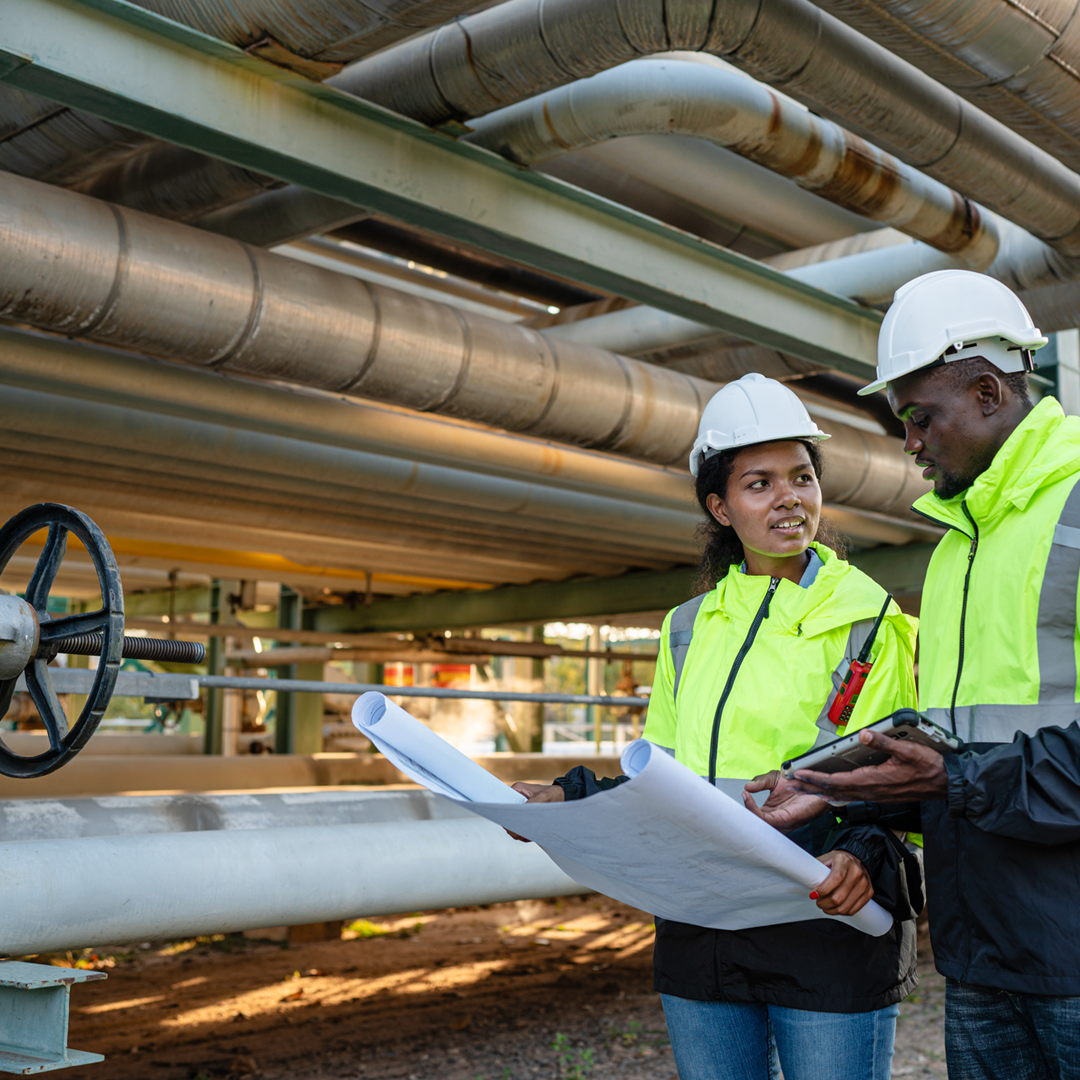 Young mechanical engineer holding blueprint drawing to checking and inspection.
