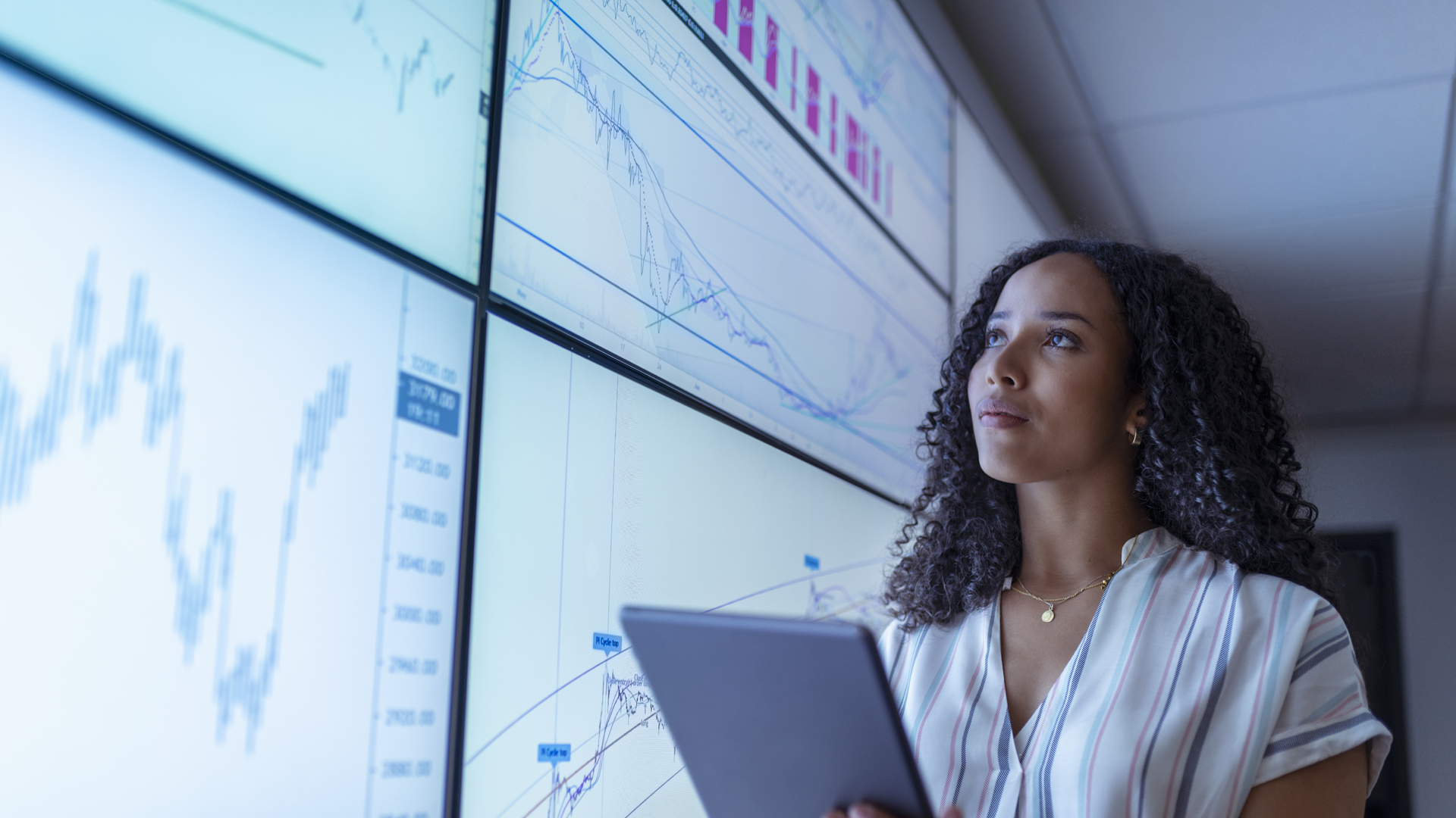 ENVATO_UK, York, Businesswoman with tablet looking at charts on interactive screens By imagesourcecurated_L0-1